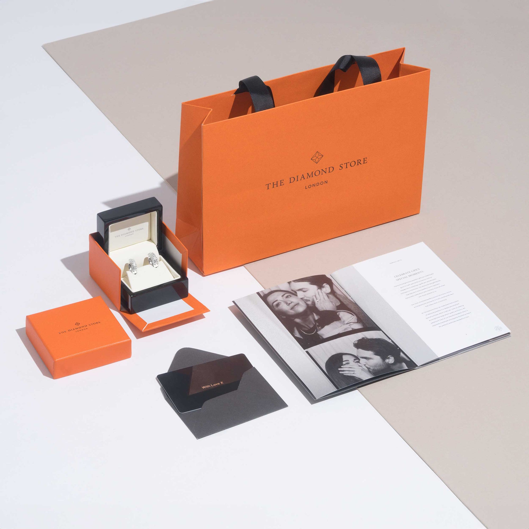 Elegant packaging from The Diamond Store, showcasing a gift bag, jewelry boxes, and a brochure.