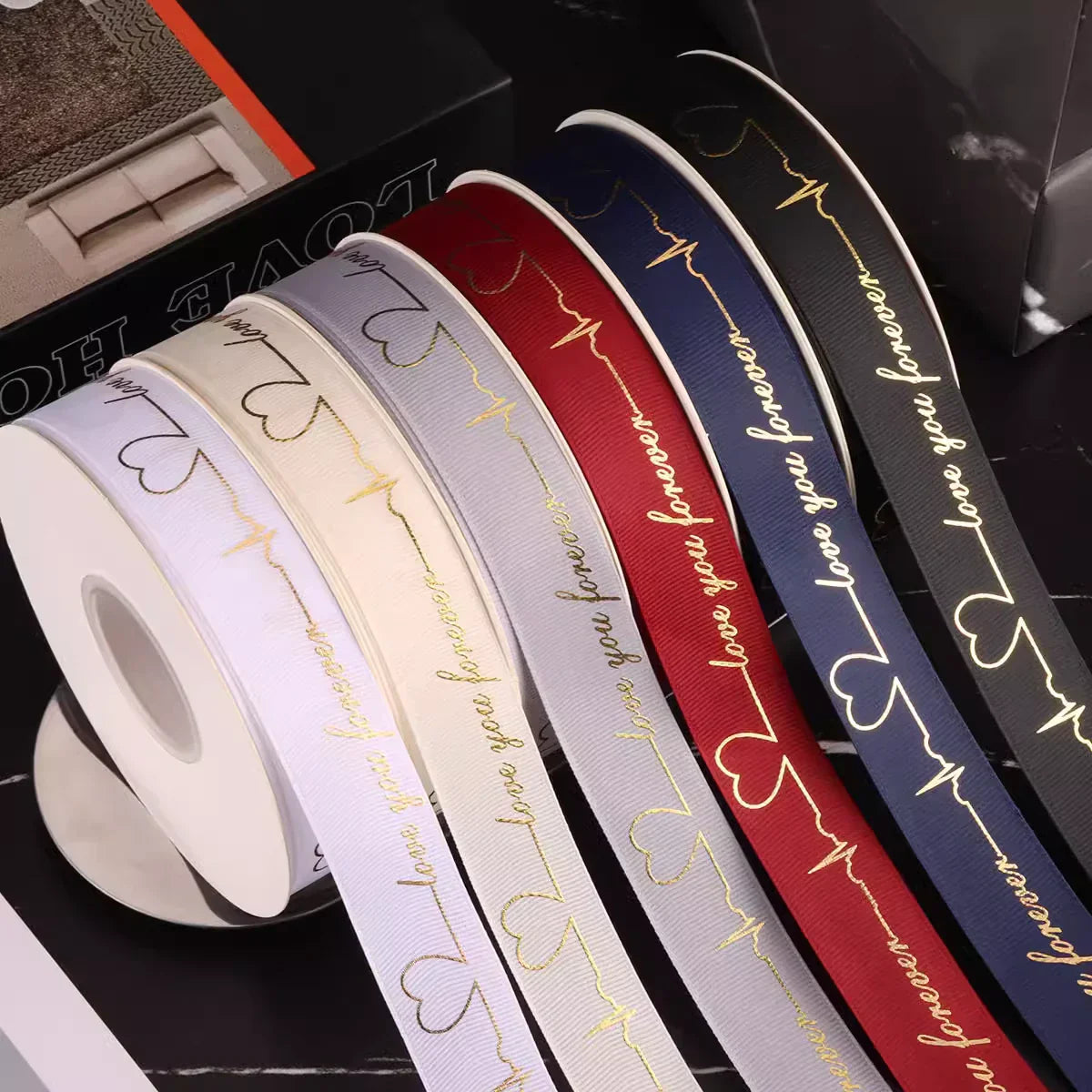 Collection of colorful heart print ribbons in various shades, perfect for crafting and event decoration.