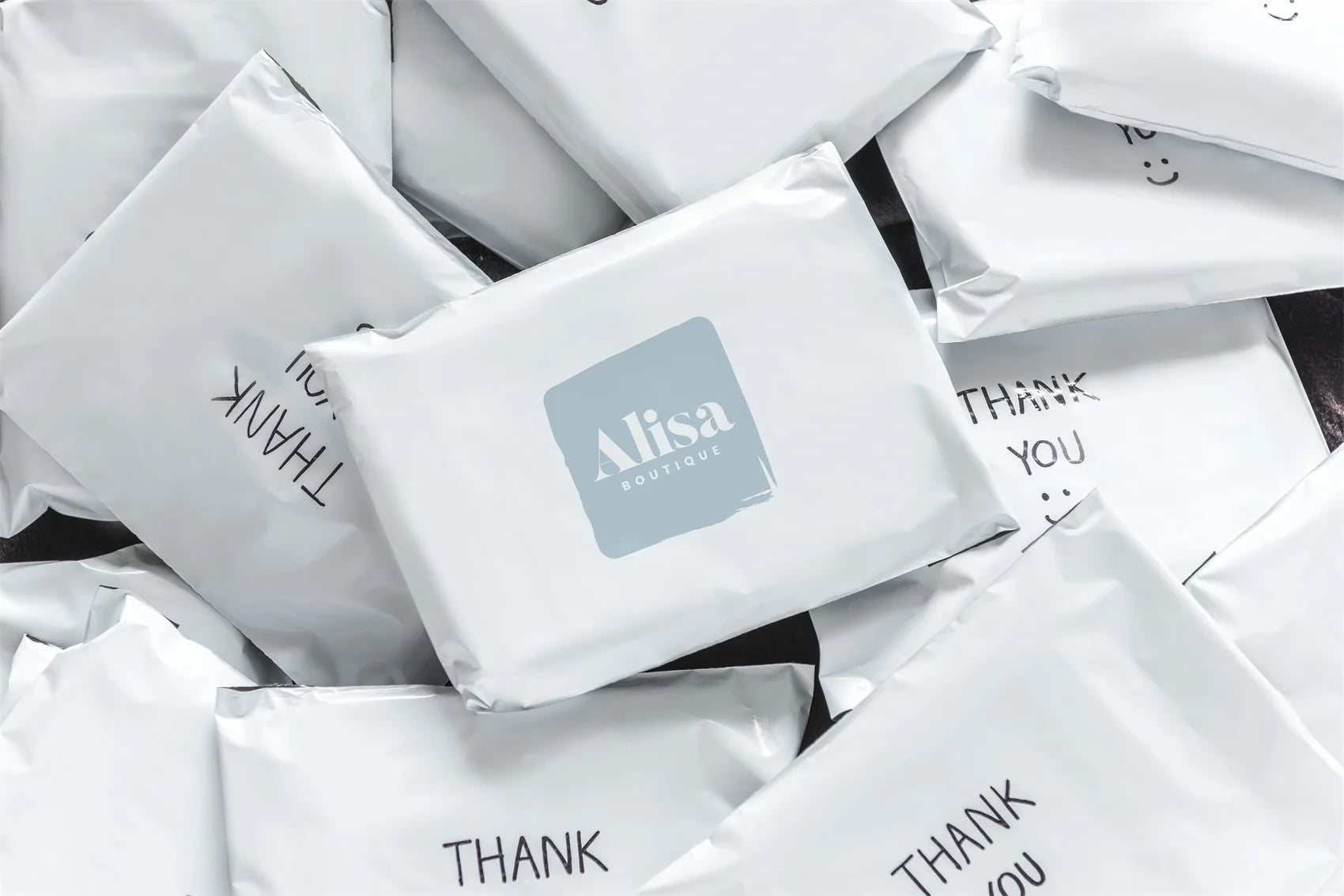 Custom poly mailers featuring a logo and thank you messages, showcasing effective branding and packaging design.