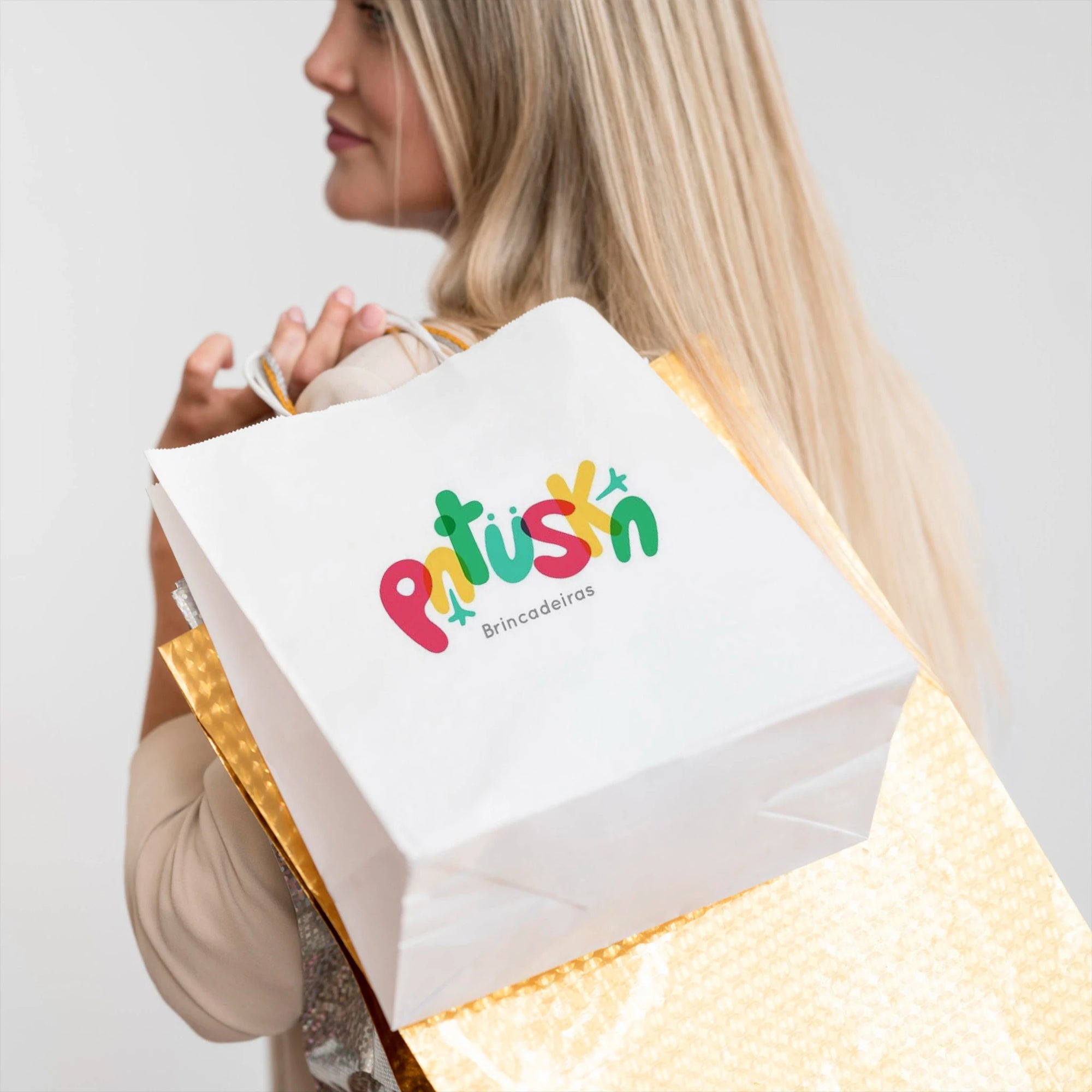 Custom white paper bag with colorful logo carried by a woman, perfect for branding and events.