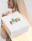 Custom white paper bag with colorful logo carried by a woman, perfect for branding and events.