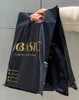 Custom die cut handle bags in black, showcasing sleek design and durability, ideal for brand promotion and packaging.