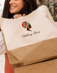 Woman smiling while carrying custom paper bags for a clothing store, showcasing eco-friendly branding.