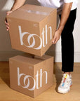 Person carrying two premium custom shipping boxes with stylish branding and durable design for secure product delivery.