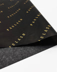 Custom tissue paper featuring black background with elegant gold "PAULASH" branding for sophisticated packaging solutions.