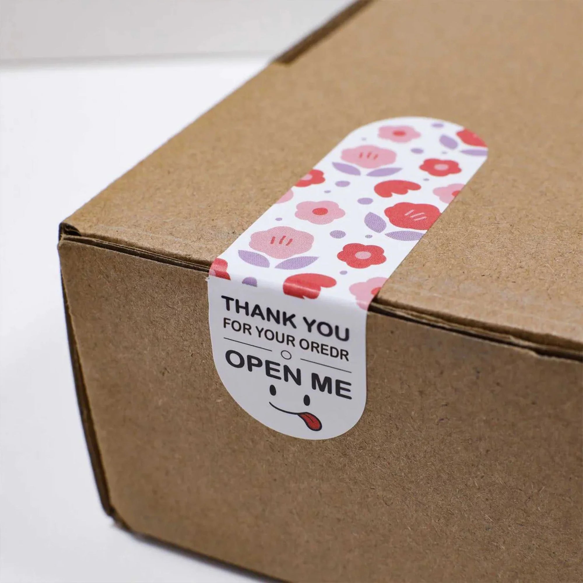 Custom floral sticker on a cardboard box with a "Thank You" message and an invitation to "Open Me".