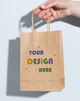 Custom paper bag held by hand, featuring personalized design elements for branding and eco-friendly packaging.