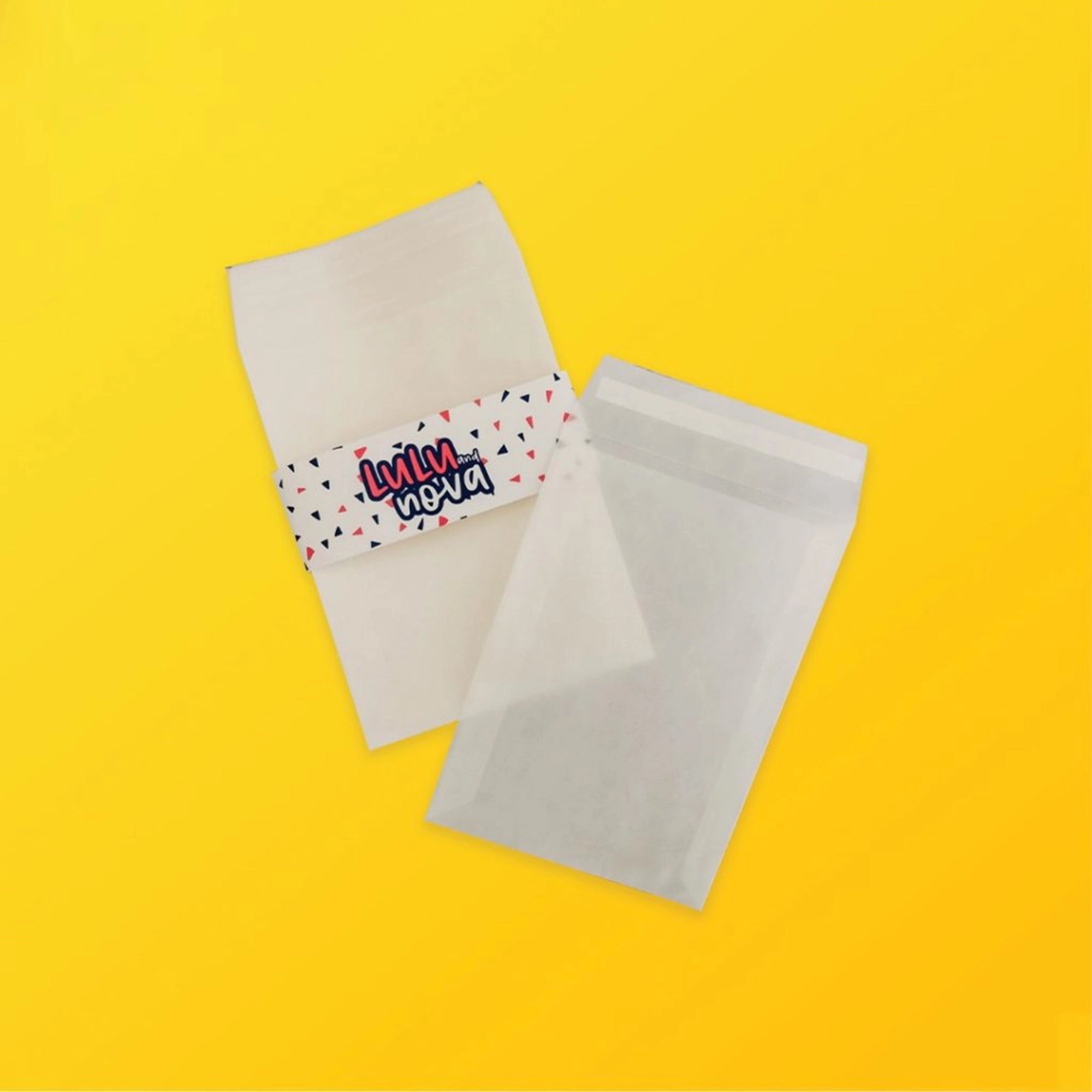 Custom glassine bags with glossy finish, 40gsm paper, ideal for packaging, featuring colorful band on a yellow background.