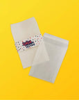 Custom glassine bags with glossy finish, 40gsm paper, ideal for packaging, featuring colorful band on a yellow background.
