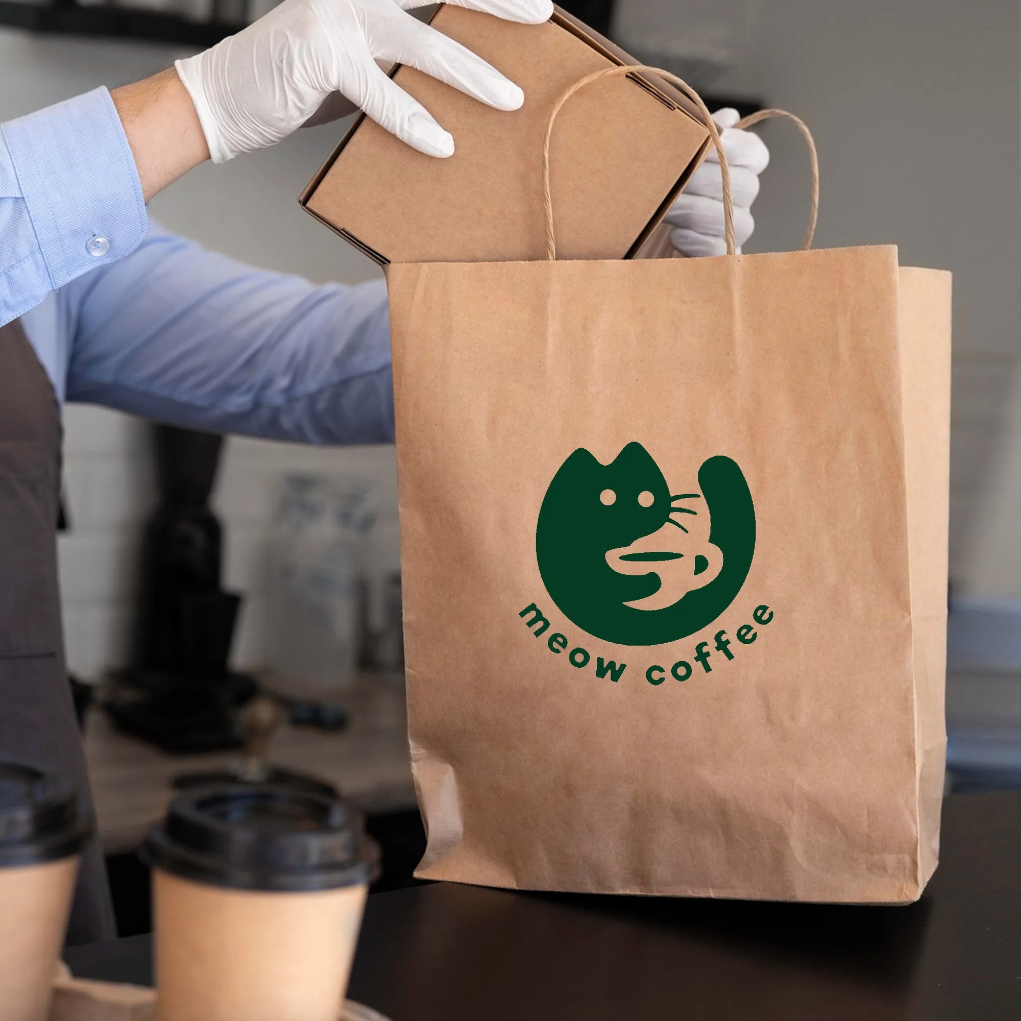 Custom paper bag with 'meow coffee' logo, held by barista, showcasing eco-friendly packaging.