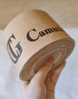 Custom water-activated tape with branded design, held in hand for secure packaging solutions.