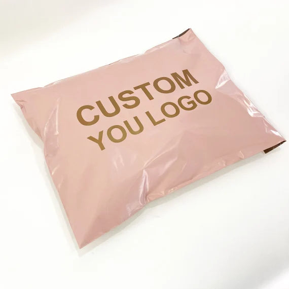 Custom pink poly mailer with "CUSTOM YOU LOGO" printed in gold for stylish shipping solutions.