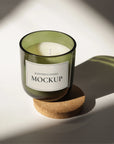 Mockup of a scented candle in a green glass jar on a cork coaster, showcasing a minimalist design.