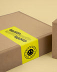 Custom packaging with vibrant yellow mockup sticker showcasing branding and design options.