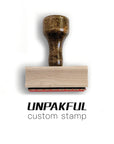 Custom rubber stamp with wooden handle for branding and personalized messaging.