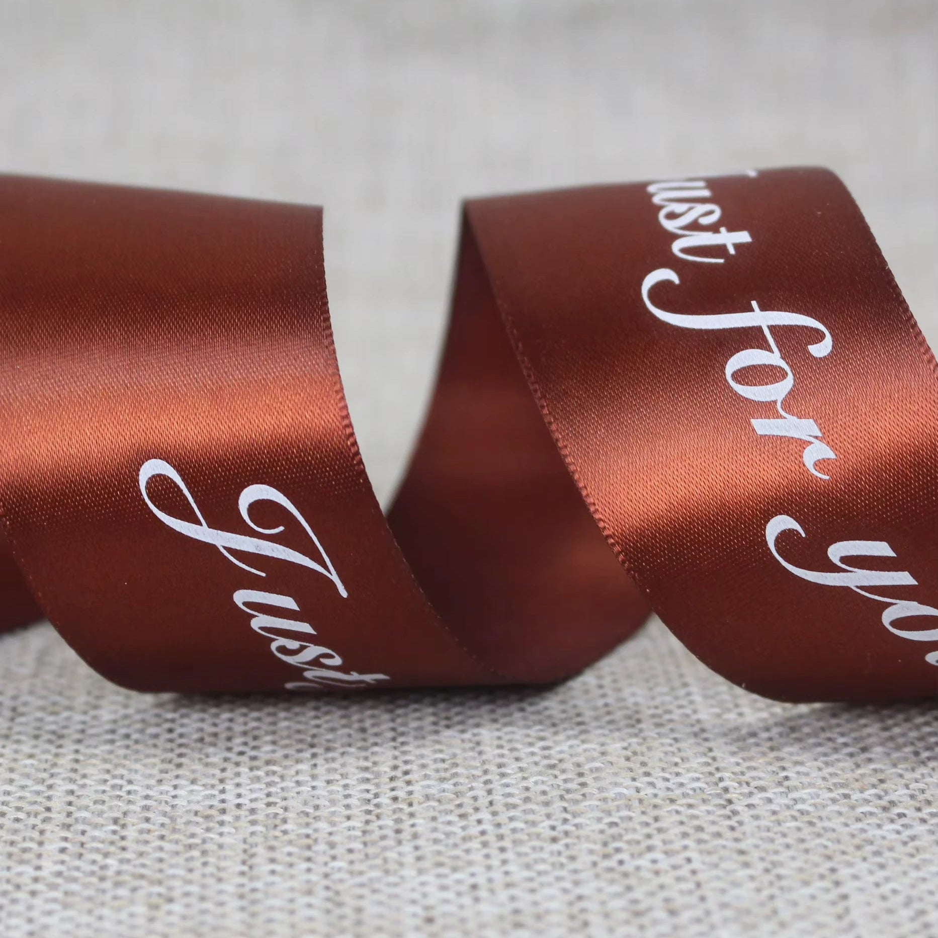 Custom satin ribbon in rich brown with "Just for you" message, perfect for elegant gift wrapping and decoration.