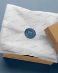 Custom round sticker on paper wrapping inside a gift box, showcasing branded packaging mockup.