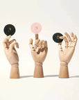 Custom round stickers showcased on wooden hands for branding and promotional use.
