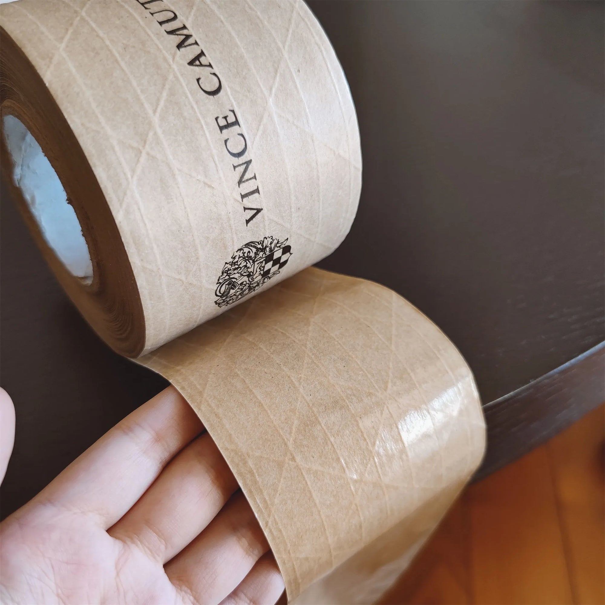 Custom water-activated tape showing reinforced design for secure packaging and branding on a table.