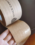 Custom water-activated tape showing reinforced design for secure packaging and branding on a table.