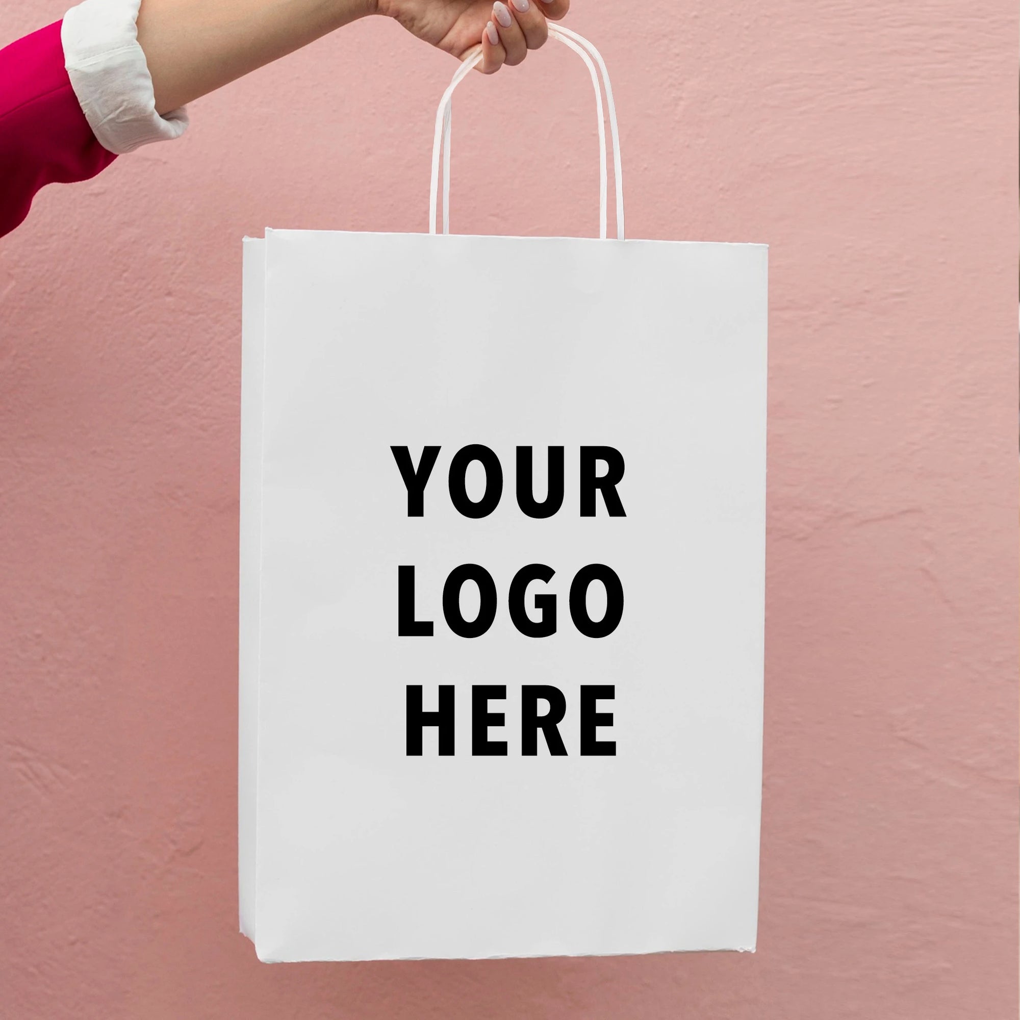Custom white paper bag held by hand, featuring placeholder text for branding with 'YOUR LOGO HERE'.
