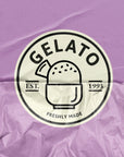 Gelato brand logo featuring a scoop in a cup, established in 1993, on a crumpled purple background.