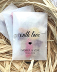 Custom glassine bags with printed design "with love" and names "Daniel & Zoe," set in natural straw decor.