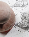 Custom rubber stamp printing an illustration of a double-decker bus on lined paper for branding purposes.