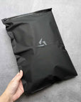 Hand holding a sleek custom black zipper bag with a matte finish, ideal for premium packaging solutions.