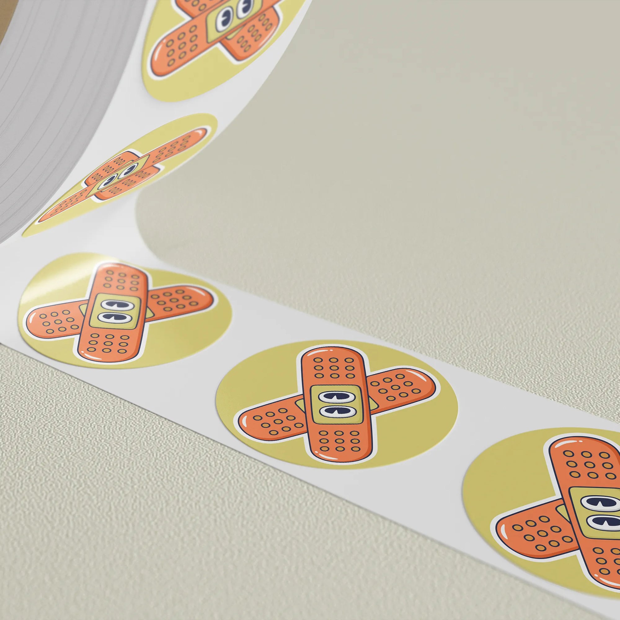 Custom round stickers with a band-aid design printed on a roll, perfect for branding and promotional use.