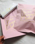 Custom pink poly mailers with gold lettering, perfect for stylish branding and secure e-commerce shipping.