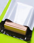 Durable wholesale poly mailer with a self-sealing adhesive strip, featuring a small cardboard box inside.