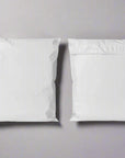 Two white poly mailers showcasing durable, tear-resistant design for safe and efficient shipping.