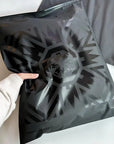 Person holding a sleek black zipper bag with a unique geometric design, ideal for stylish packaging.