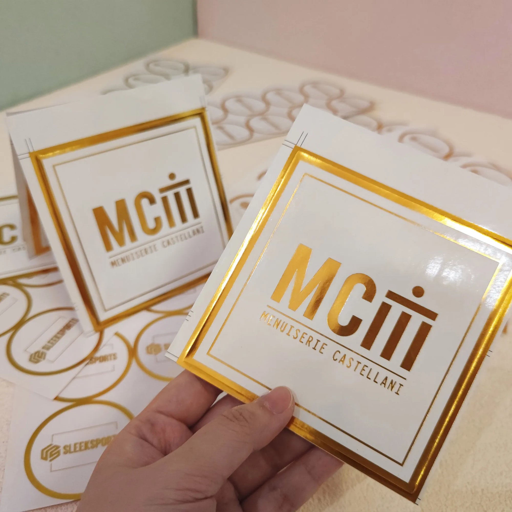 Custom square stickers featuring the logo of Menusserie Castellani with a gold and white design.