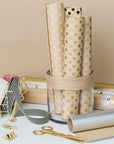 Custom tissue paper rolls in a glass holder showcasing polka dot designs, perfect for stylish packaging solutions.