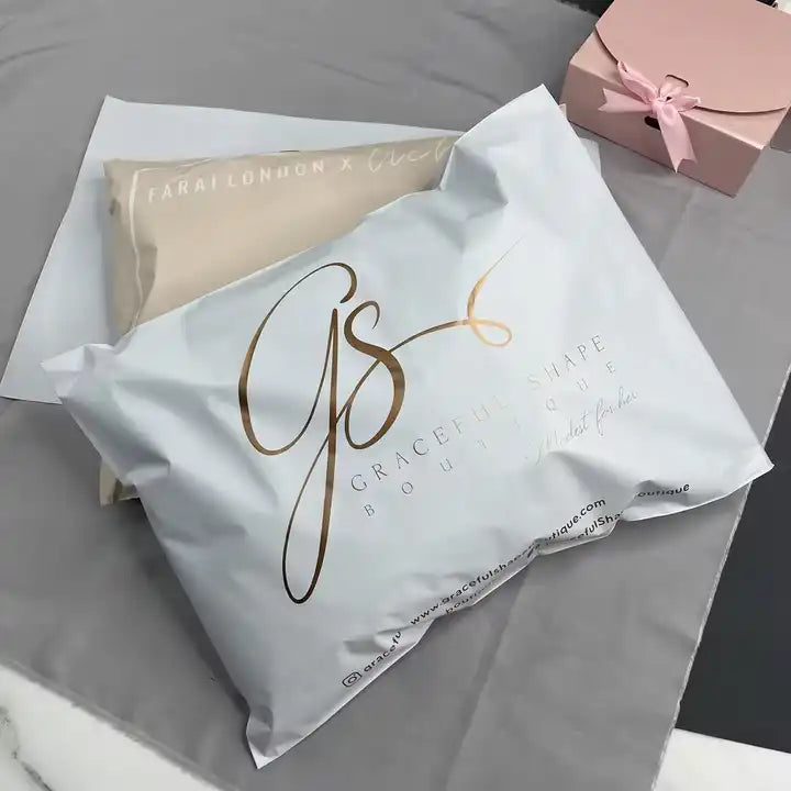 Custom poly mailers with stylish branding from Graceful Shape Boutique on a neutral background.