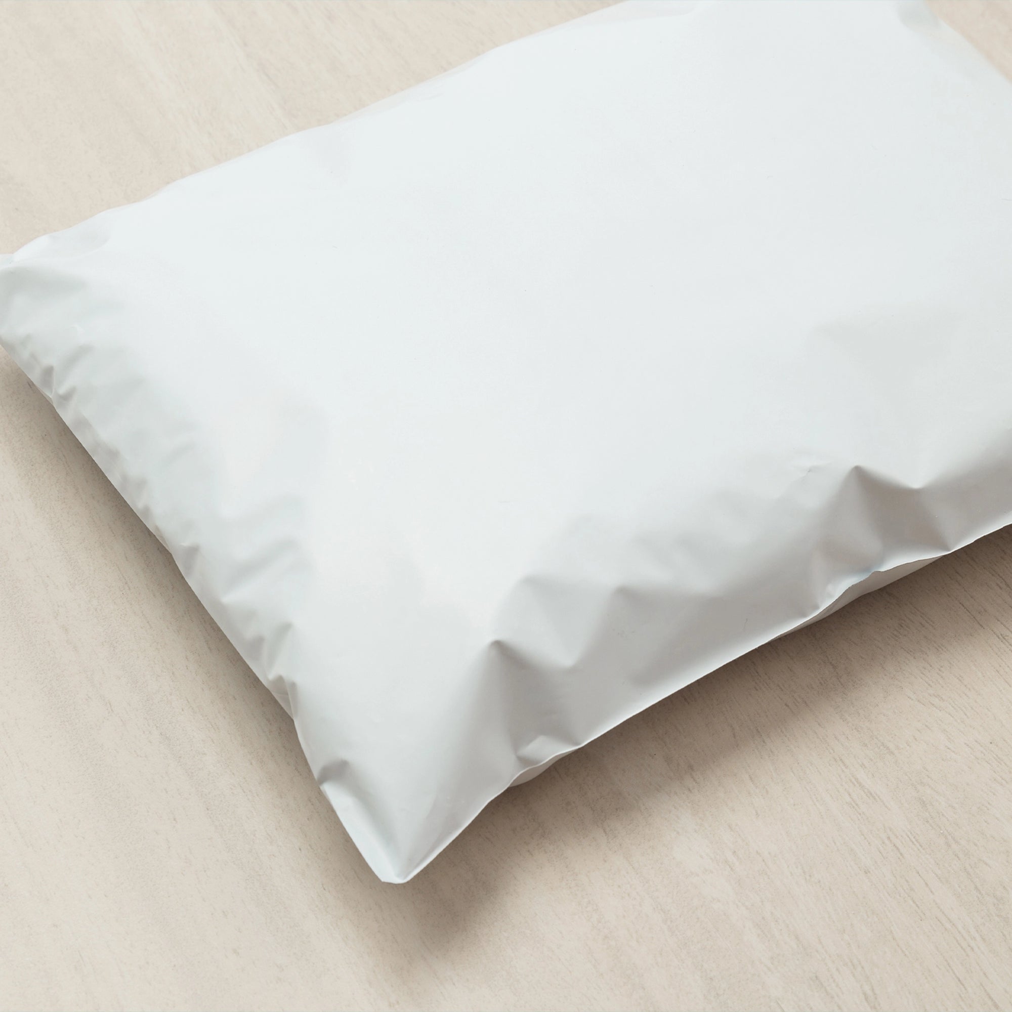 Wholesale poly mailer on a wooden surface, showcasing its durable and lightweight design for secure shipping.