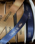 Custom metallic Lurex ribbons in gold and navy with printed designs, perfect for elegant packaging and décor.