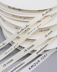 Custom cotton ribbon rolls featuring elegant scripts like "Thank you" and "Handmade" for personalized packaging and crafts.