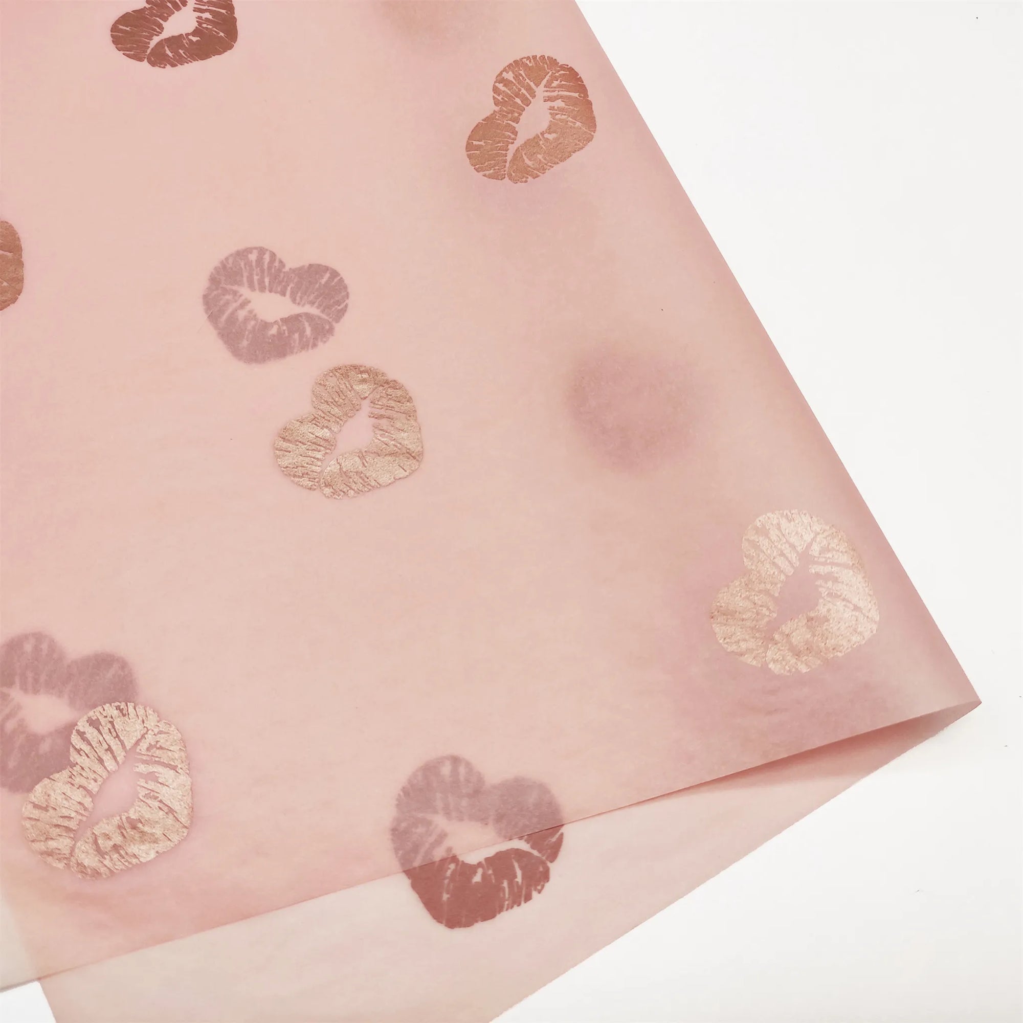 Custom pink tissue paper with gold heart and lip print, perfect for elegant packaging and branding.