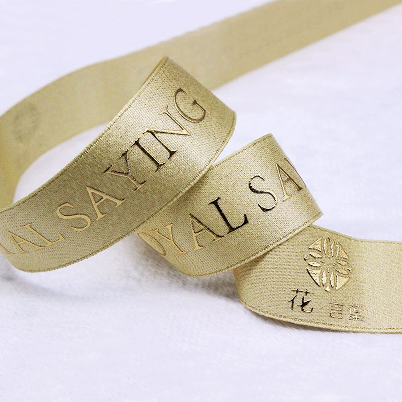 Custom metallic Lurex ribbon in gold with embossed text, ideal for elegant packaging and personalized event décor.