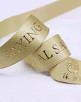 Custom metallic Lurex ribbon in gold with embossed text, ideal for elegant packaging and personalized event décor.