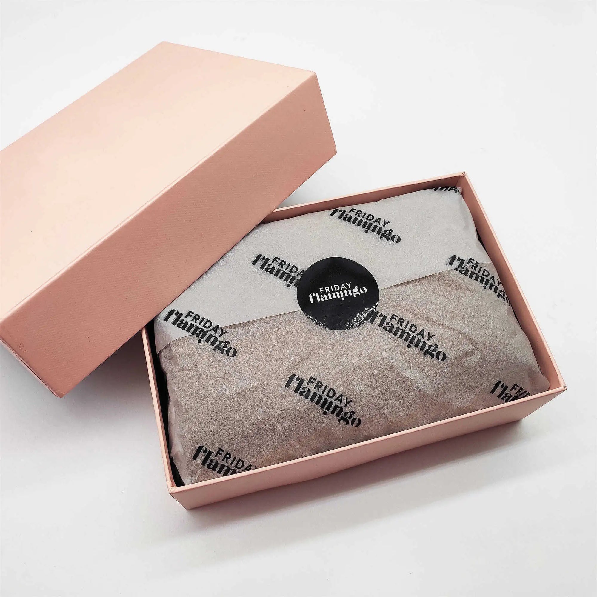 Custom tissue paper elegantly wrapped inside a pink gift box, enhancing brand presentation and unboxing experience.