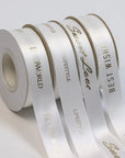 Custom satin ribbon rolls with elegant phrases for gifts and events, showcasing luxurious double-faced satin finish.