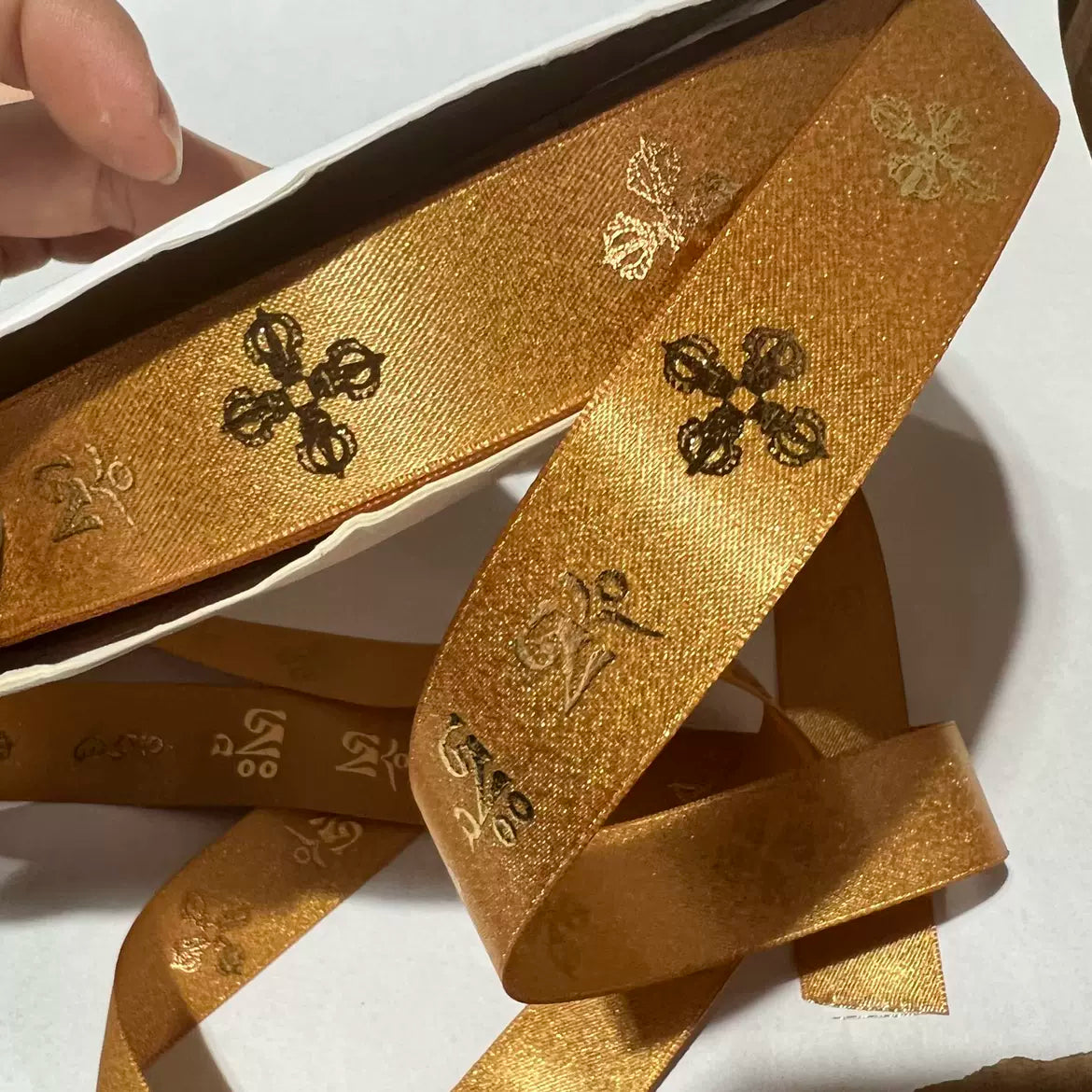 Custom metallic Lurex ribbon in gold, showcasing intricate patterns and a luxurious sheen, ideal for festive projects.