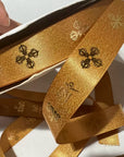 Custom metallic Lurex ribbon in gold, showcasing intricate patterns and a luxurious sheen, ideal for festive projects.