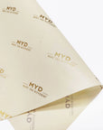 light yellow tissue paper branded with gold logo