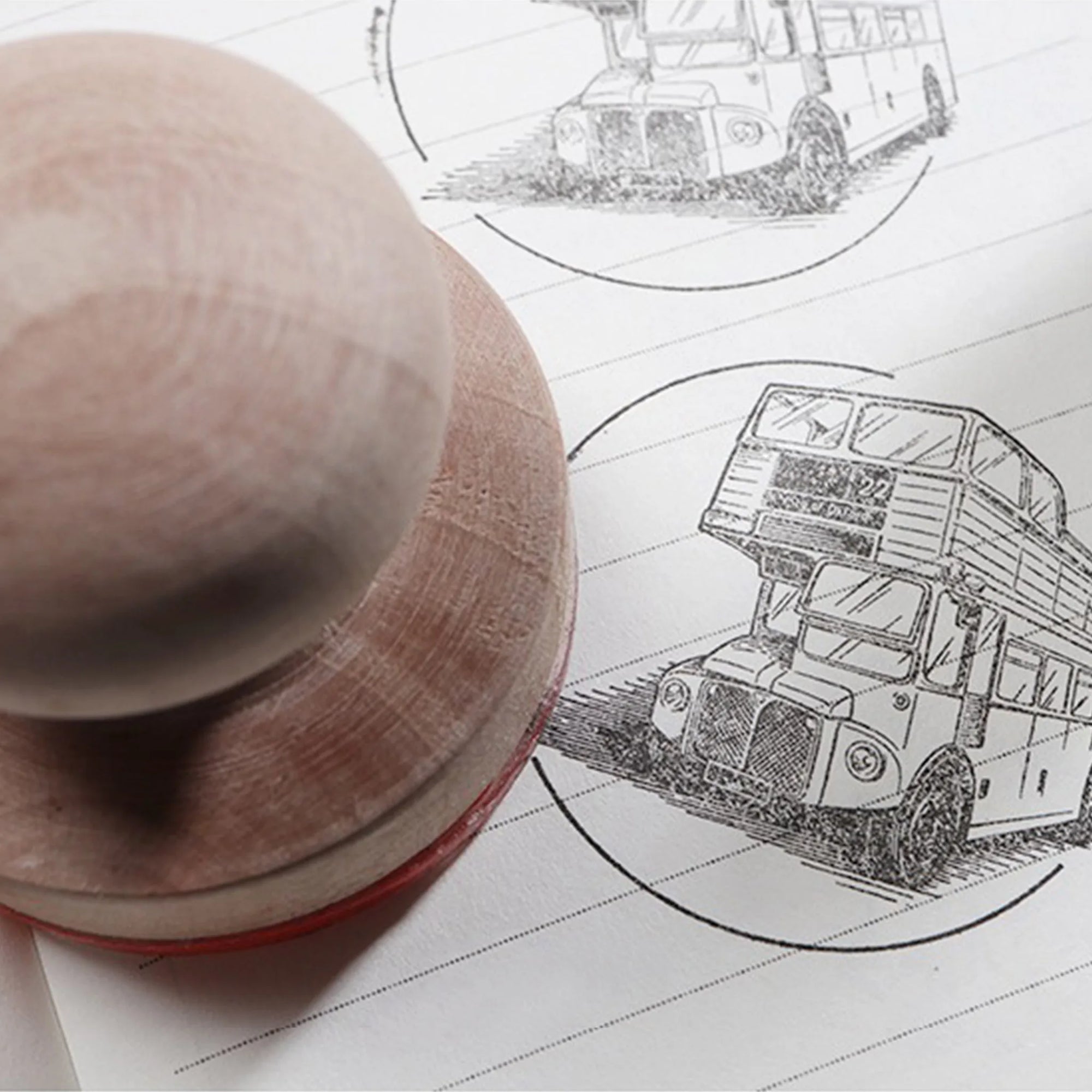 Custom rubber stamp printing an illustration of a double-decker bus on lined paper for branding purposes.