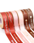 Custom satin ribbons in various colors with gold lettering, perfect for gifts and event decoration.